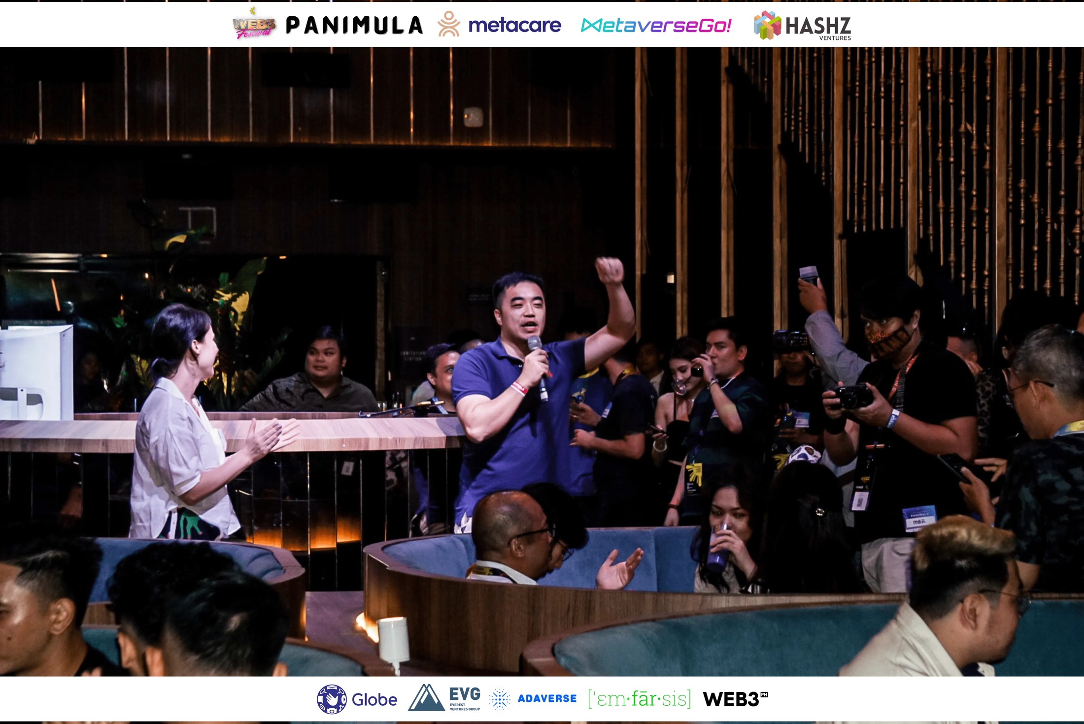 An emcee speaking with guests seated at tables during Panimula